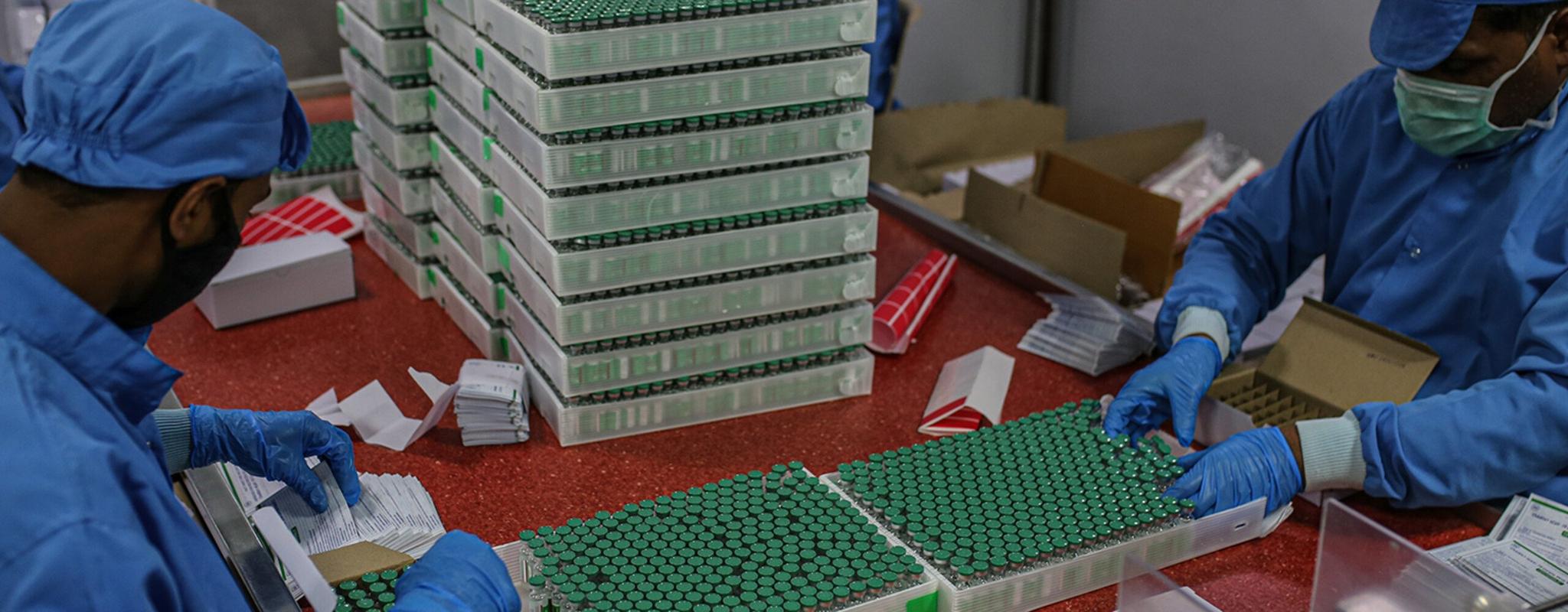 Employees packing boxes with COVID-19 vaccine at the packaging and dispatch department in Pune, Maharashtra, India