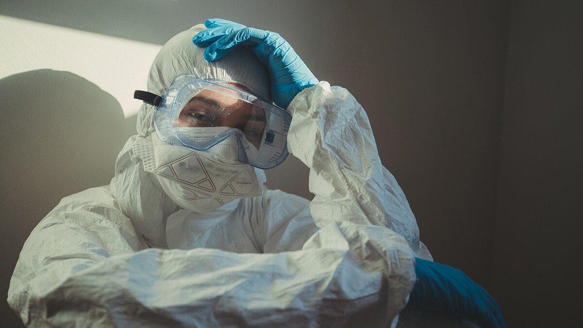 Female doctor sitting with head in hands