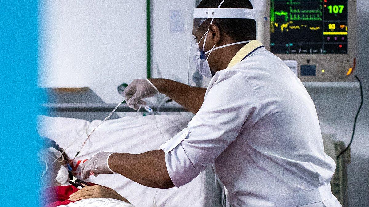 An intensive care nurse attends to a patient that is being treated for COVID-19 at a hospital.