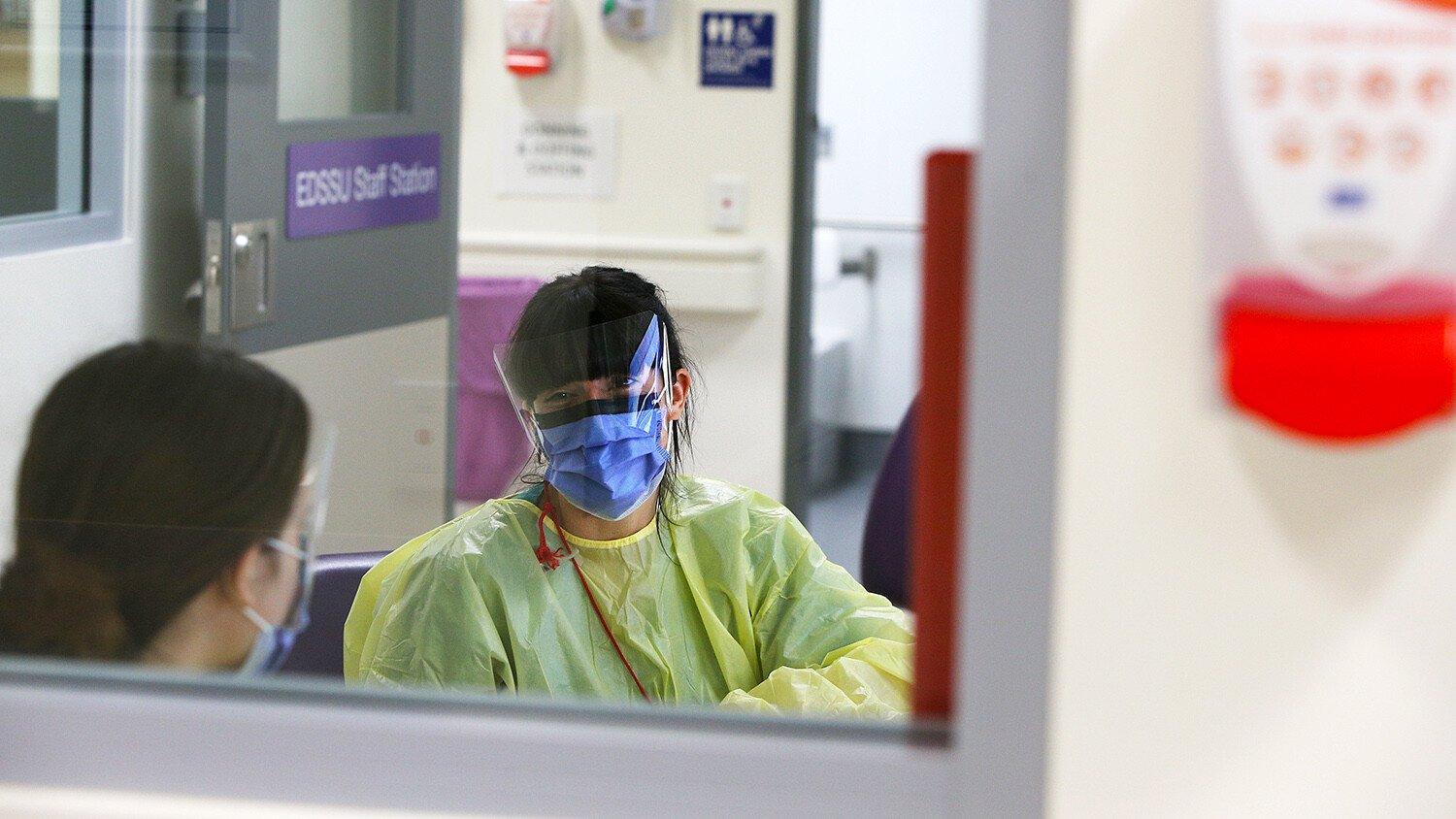 Two nurses talk in a hospital.