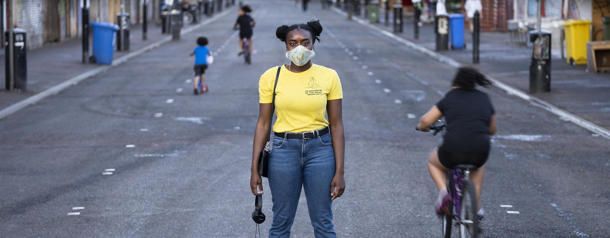 A portrait of a masked pedestrian on London's Ridley Road. 