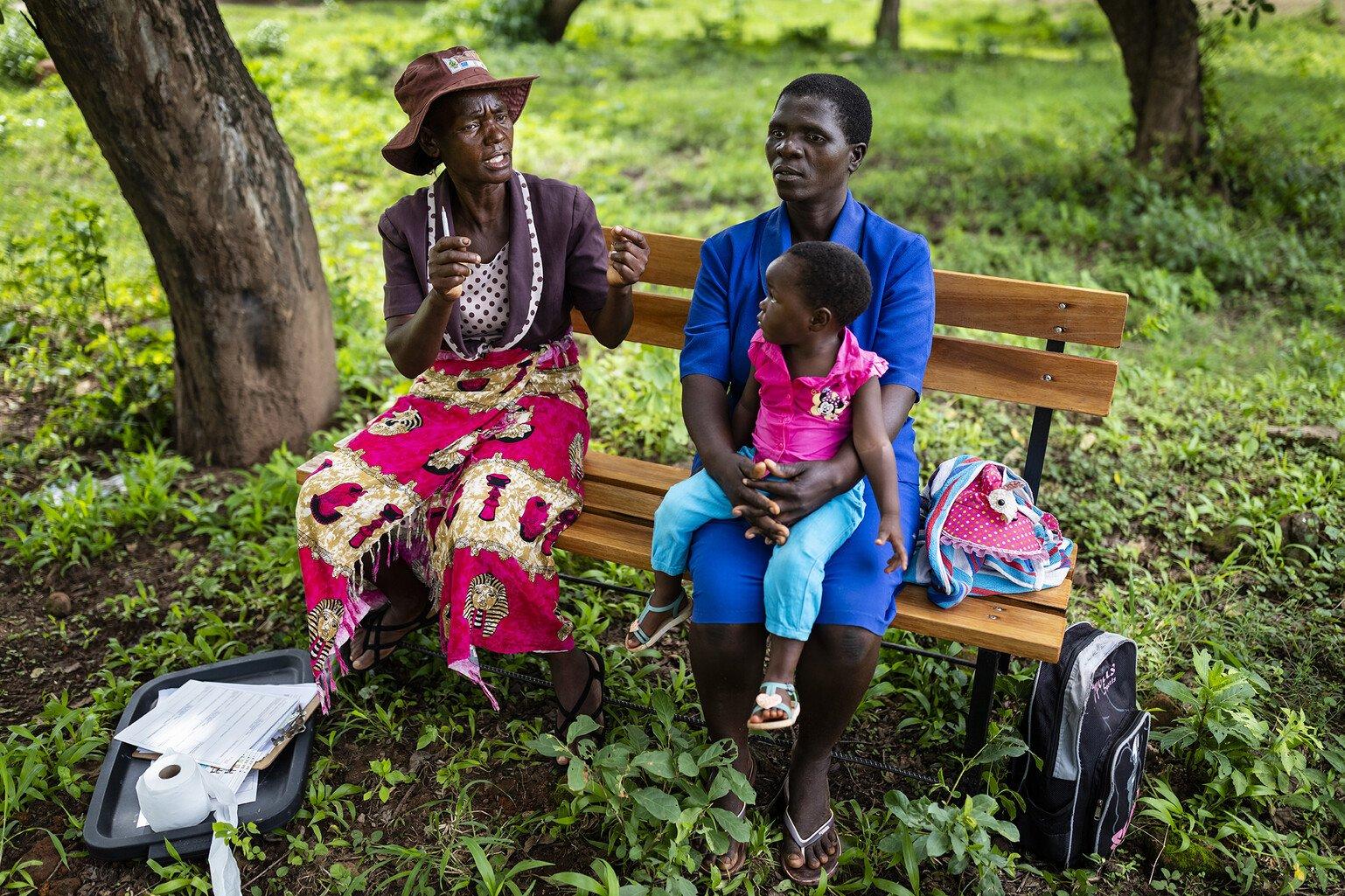 A volunteer with Zimbabwe's Friendship Bench programme gives advice.