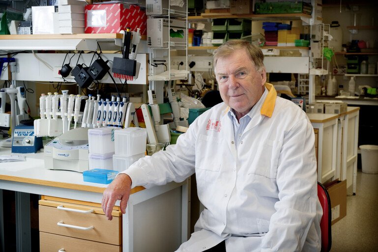 Professor Jan Holmgren sits in a laboratory wearing a white lab coat.