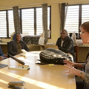 Liz and three members of her team in a meeting room