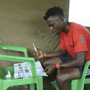 A young man reads the instructions of the HIV self-testing kit