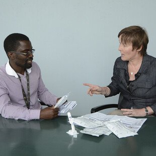 Liz Corbett and Augustine Choko demonstrate how to use the HIV self-testing kit