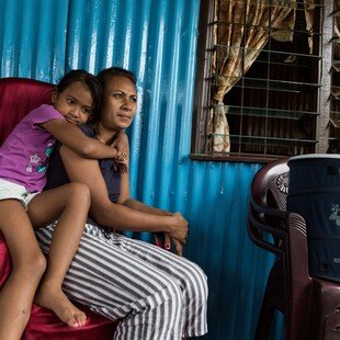 Mother and daughter sitting by their mosquito trap