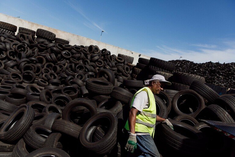 Man separating reusable tyres at a waste management site