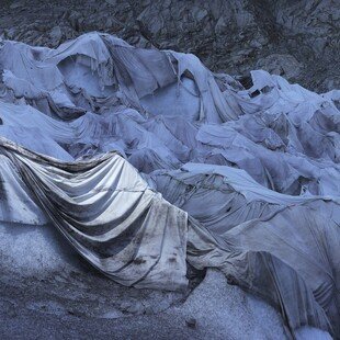 Glacier partly covered with geosynthetic blankets to reflect away the sun's heat