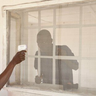 A man suspected of having Ebola has his temperature measured at a clinic run by the NGO Emergency in Sierra Leone