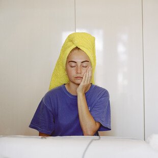 Portrait of a woman with her wet hair wrapped up in a towel