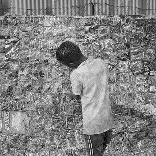 A boy makes a mat to play with out of packing he has found