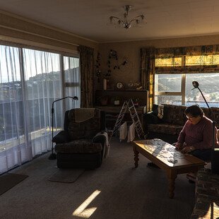 A woman does a jigsaw puzzle in her lounge