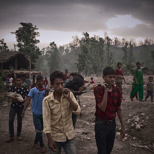 Four men carry a new mother from her village to the nearest hospital 