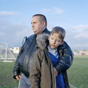 A father who is blind wraps his arms around his son on their way home from school