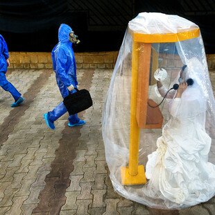 A staged image depicting a woman in a wedding dress, calling her groom from inside a protective bubble. 