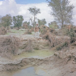 A man stands on the drought-ridden land he uses for crops. 