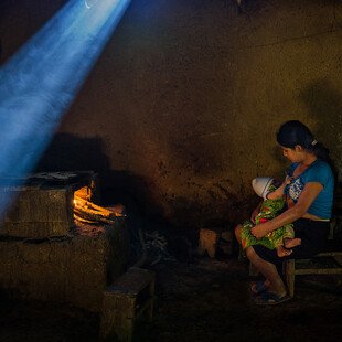 A young, malnourished mother is breastfeeding her underweight son.