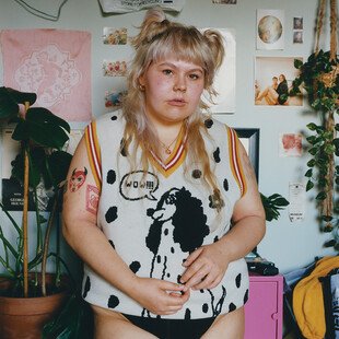 A woman standing in her bedroom. 