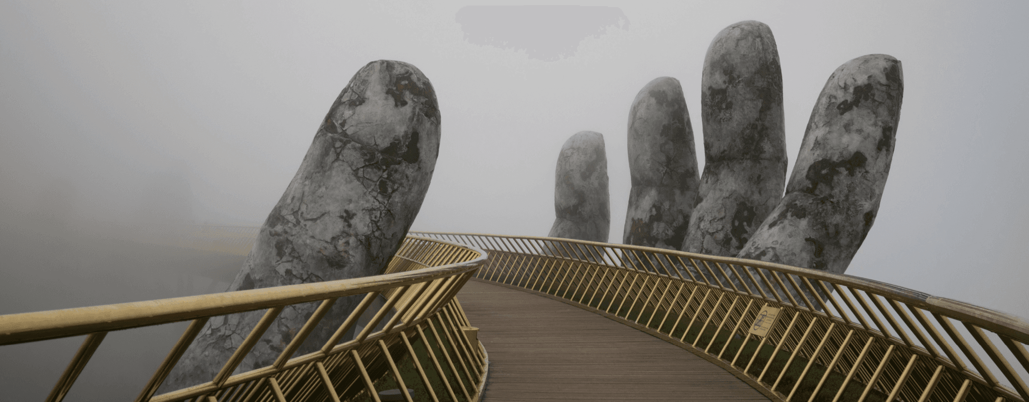 An image of a footbridge supported by a statue of a hand 