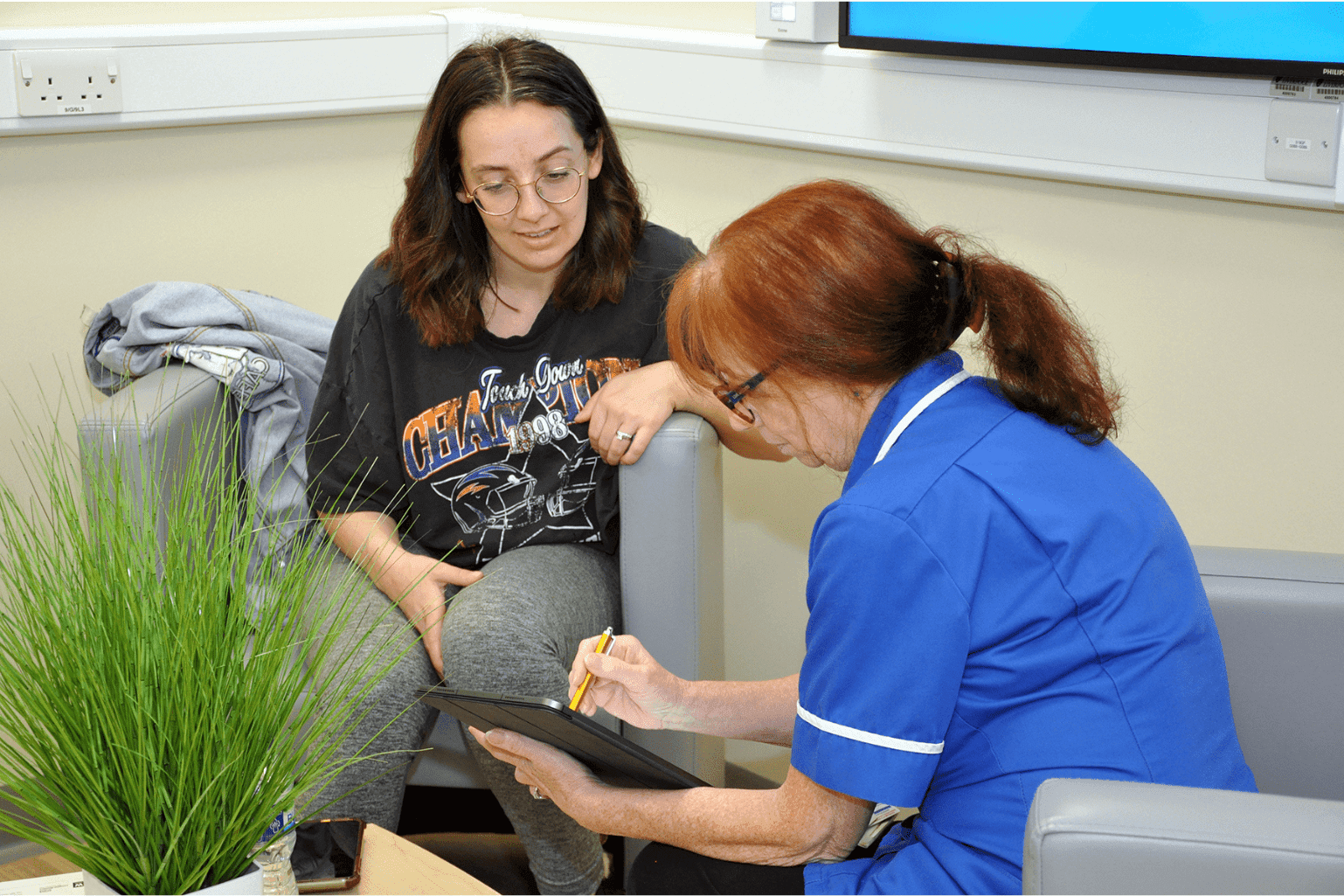 The photo shows Irene Reppion, a Research Midwife at Liverpool Women's Hospital, seated with a C-GULL participant discussing the study consent forms and information sheet.